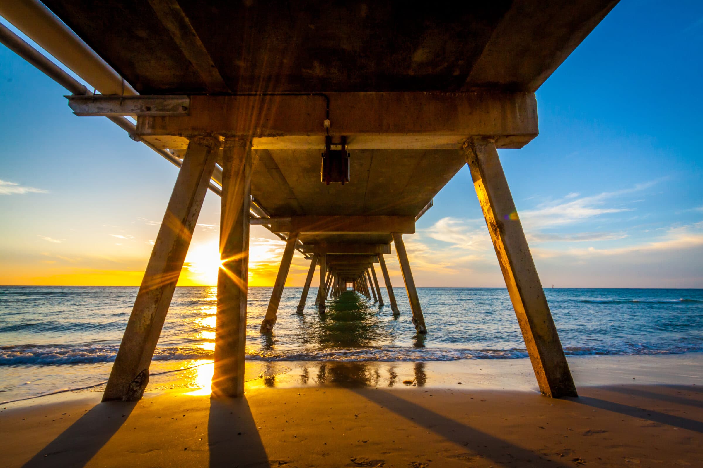 The Glenelg jetty at Adelaide, South Australia, silhouetted against a sunset over the water