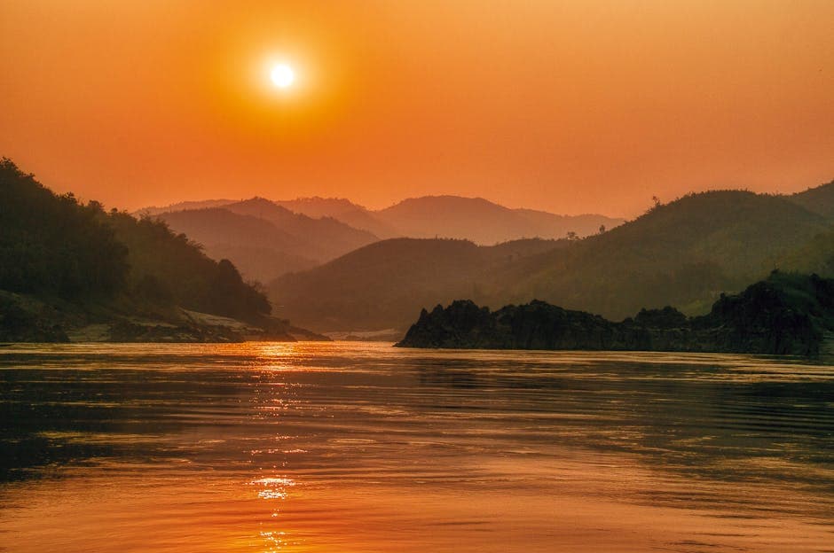 Serene sunset landscape over the Mekong River with scenic mountains in the background