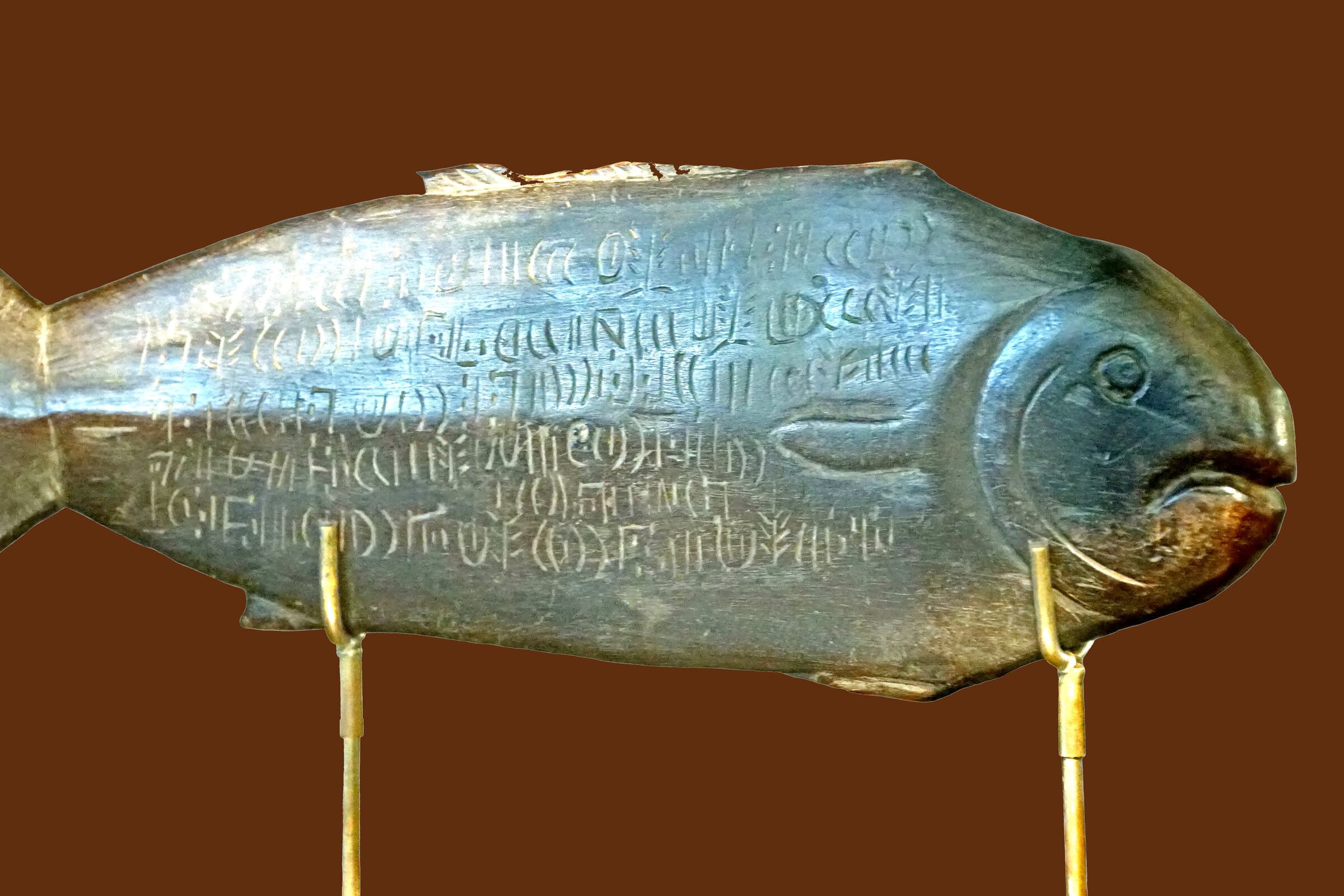 A fish-shaped wooden rongorongo object covered edge to edge with rows of incised Easter Island glyphs