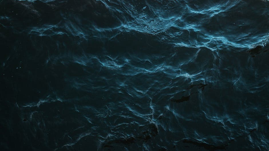 Mysterious dark water surface with subtle light reflections and deep blue hues