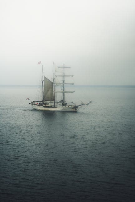 A sailboat in foggy waters at dawn, showing how quickly visibility can deteriorate at sea in conditions like those found in the Bermuda Triangle