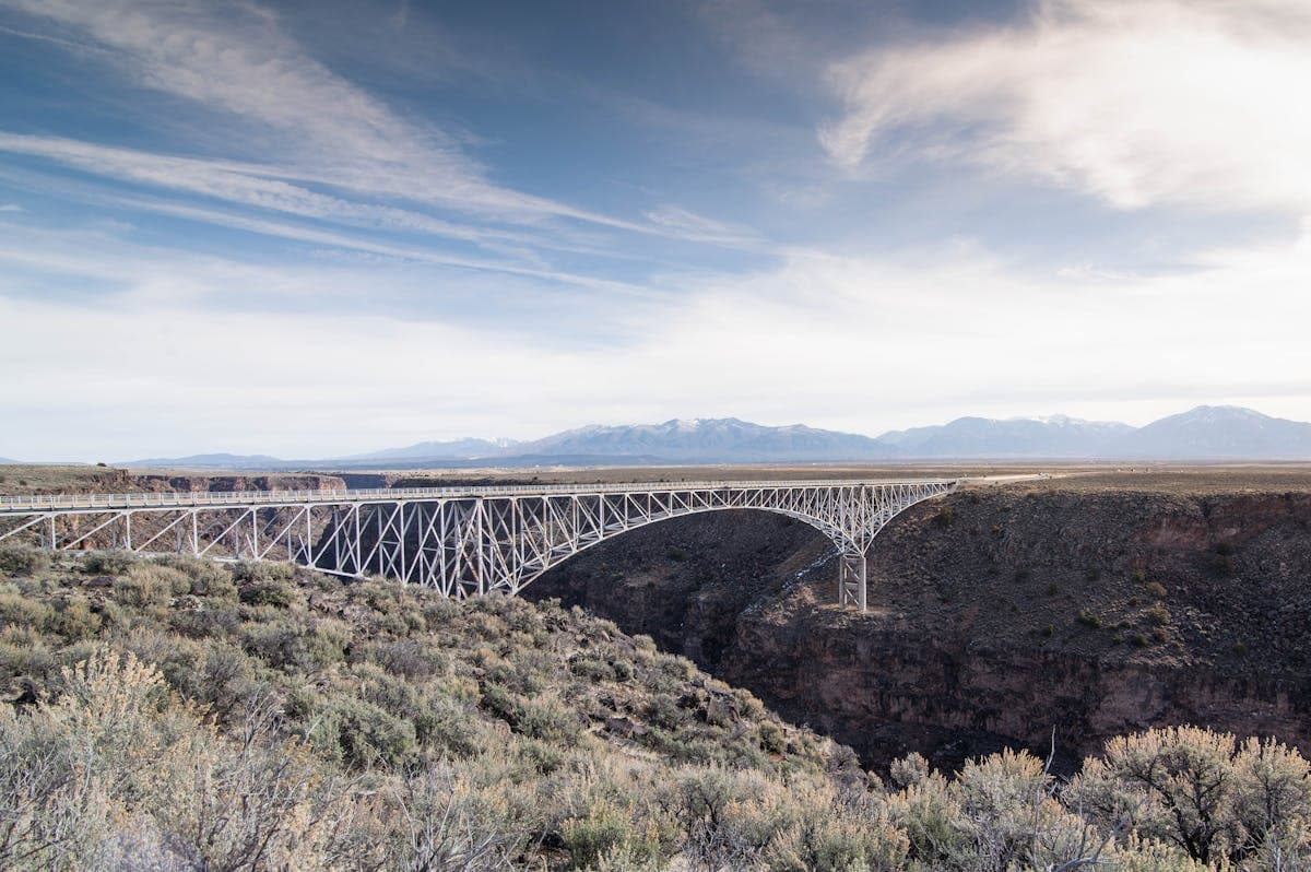 Scenic view of the Rio Grande Gorge Bridge with mountain backdrop near Taos, New Mexico